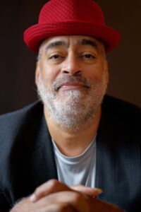 Photo of Vance Gilbert in a red hat.